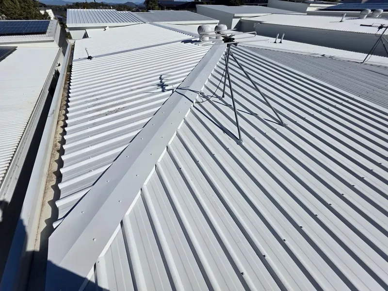 New Colorbond roof with crisp hips and ridges under blue sky